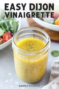 an easy dijon vinaigrette recipe in a mason jar next to a bowl of salad