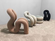 three different shaped objects sitting on top of a carpeted floor next to each other