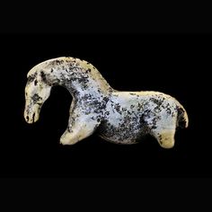 a white and black horse statue against a black background