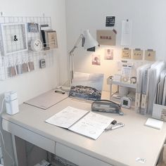 a white desk topped with a lamp and pictures