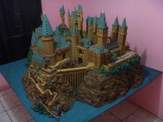 a cake made to look like a hogwarts castle on a blue tablecloth