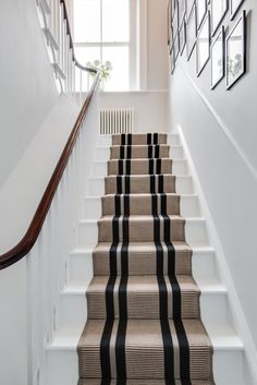 the stairs are lined with black and white striped carpet