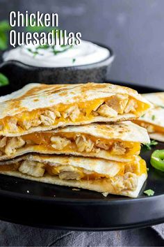 chicken quesadillas on a black plate with jalapenos in the background