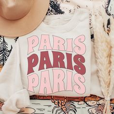 This cozy Paris France sweatshirt features a classic design with the iconic Eiffel Tower standing tall in the center. The soft cotton fabric is perfect for wearing on a cool day while exploring the City of Light. The comfortable fit and stylish design make this sweatshirt a must-have for any traveler's wardrobe. Whether you're taking a stroll along the Seine or enjoying a café au lait at a local café, this timeless piece of clothing will keep you looking stylish and feeling comfortable. Note: ♡ White French Terry Top With Graphic Print, Travel To France, Paris Sweatshirt, The Seine, France Travel, Size Charts, Stylish Design, Piece Of Clothing, Timeless Pieces