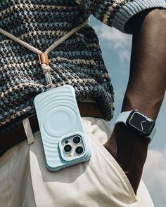 an iphone case is attached to the back of a man's pants while holding his cell phone