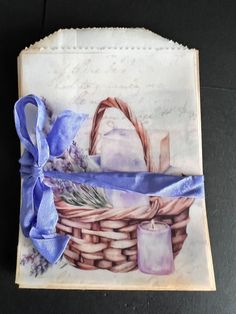 an image of a basket with candles and lavenders on it, wrapped in blue ribbon