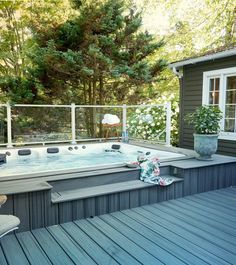 a large hot tub sitting on top of a wooden deck