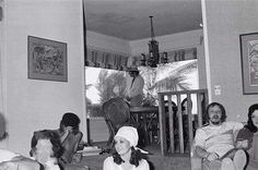 black and white photograph of people sitting in a living room