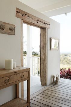 a wooden table sitting on top of a hard wood floor next to a white wall