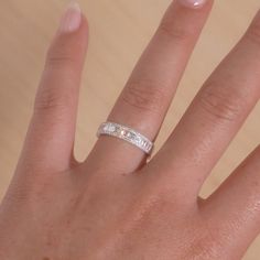 a woman's hand with a wedding ring on top of her finger, showing the diamond band