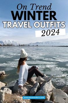 a woman sitting on rocks near the water with text overlay that reads, on trend winter travel outfits 2021