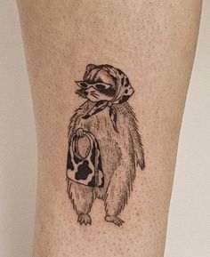 a tattoo on the leg of a person with a hat and scarf around his neck