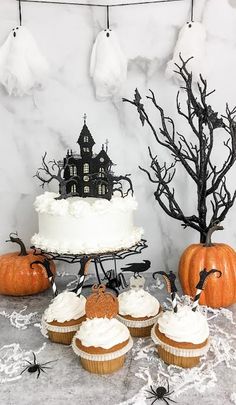 a table topped with cupcakes covered in frosting and spooky decorations