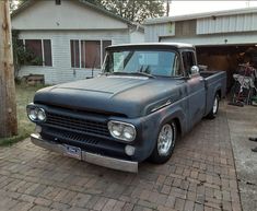 an old pickup truck parked in front of a house