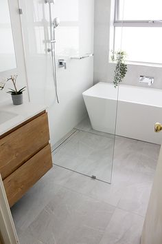 a bathroom with a sink, bathtub and shower in it's own area