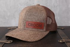 a brown hat with the word groom on it sitting on top of a piece of luggage