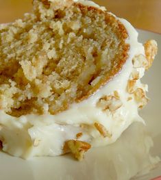 a piece of cake with white frosting and nuts on it sitting on a plate