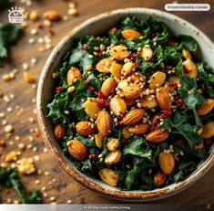 a bowl filled with nuts and greens on top of a wooden table