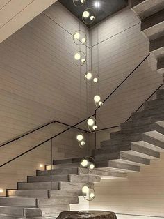 a room with some stairs and lights hanging from the ceiling over it's head