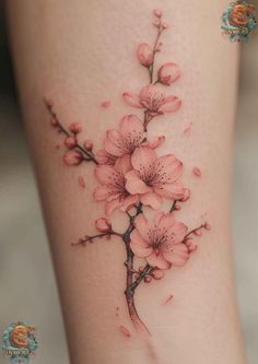 a tattoo with pink flowers on the side of a woman's leg and it is shown