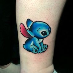 a small blue tattoo on the leg of a person with an elephant in it's lap