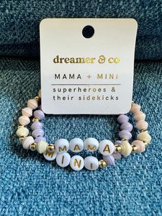 We mamas love our minis. When we get to see the joy of innocence in their eyes, hear them laugh at something for the first time, and wipe their tears when they experience sadness -- getting to be their mama is a privilege, no matter how your mini joined your family.  Our mini bracelet is made for stacking with our bracelet created just for our little girls. We also love our mini kid bracelet so much we made a special Mama + Mini bundle. Now you can both wear your favorite handmade beaded bracelets together! Wear your word with pride as you remember the blessings of motherhood. Each bead is made from paper by women in the Horn of Africa. They use colored paper that they measure, cut, roll, and varnish to make a beautiful, unique, bead. Once the beads are dry, they are used to assemble and m Mini Bracelet, Horn Of Africa, Travel Cases, Kids Bracelets, Toiletry Kit, Bracelets Handmade Beaded, Toiletry Storage, Colored Paper, Arm Band