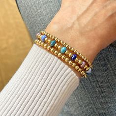 14K gold-filled or sterling silver 2mm, 3mm, & 4mm beads; colorful glass seed beads; 6mm glass bubble beads; stretch style. Water safe, tarnish-resistant. Great solo or stacked. Bracelet Size Guide Blue Crystal Bracelet With Stackable Round Beads, Blue Stackable Stretch Bracelet, Stackable Blue Stretch Bracelet, Blue Stackable Beaded Bracelets As Gift, Blue Spiritual Stackable Beaded Bracelets, Stackable Crystal Bracelet With Round Beads, Blue Stackable Stretch Bracelet For Everyday, Everyday Polished Beaded Bracelets, Everyday Blue Jewelry With 8mm Beads