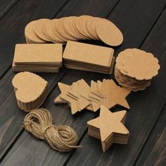 some brown paper tags and string on a wooden table with other items to make them look like stars