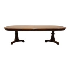 an oval dining table with two pedestals on the legs and a rectangular wooden top