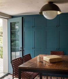 a kitchen with blue cabinets and a wooden table