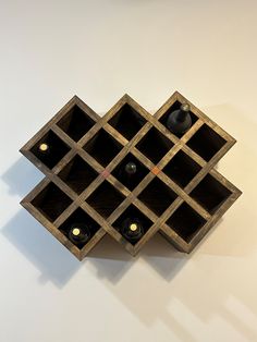 a wine rack made out of wood with bottles in the middle and lights on each side