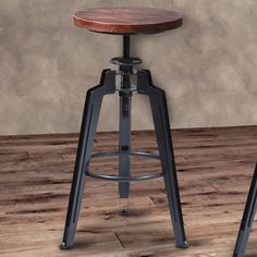 an industrial style stool with wooden seat and metal frame on wood floor in front of wall