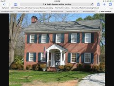 a red brick house with blue shutters on the front and side windows is shown