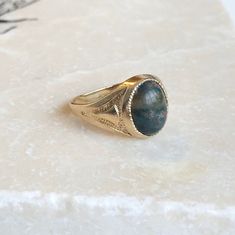 A Fine Vintage 9 carat Gold signet ring with a cabochon Bloodstone. A timeless piece that is bold and classic, a great ring for everyday wear. The detailing down the shoulders really finish it perfectly. CONDITION: Very good condition, please see photos for more detail STONE FACE: 10mm x 8mm RING SIZE: UK: I 1/2 | US: 4 1/2 RING WIDTH (SMALLEST): 2mm SETTING AND STONE HEIGHT: 5mm WEIGHT: 2.5 grams Timeless Cabochon Sapphire Ring, Classic Cabochon Sapphire Ring For Formal Occasions, Classic Formal Cabochon Sapphire Ring, Classic 14k Gold Sapphire Oval Cabochon Ring, Classic Formal Sapphire Cabochon Ring, Classic Gold Signet Ring With Gemstone, Classic Yellow Gold Sapphire Ring With Cabochon, Classic Sapphire Ring Oval Cabochon, Classic Yellow Gold Signet Ring With Cabochon