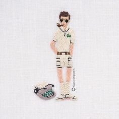 a cross stitch picture of a man with sunglasses and a small dog on the ground