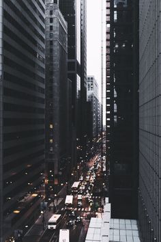 a city street filled with lots of traffic next to tall buildings in the middle of the day