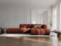 an orange couch sitting on top of a hard wood floor next to a white wall