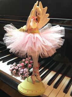 a doll is standing on top of a piano