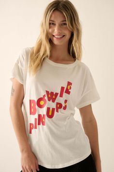 David Bowie Pinups Garment-Wash Graphic Tee - ShopPromesa Pop Culture Slogan Tops With Relaxed Fit, Relaxed Fit Slogan Tops For Pop Culture, Band Merch Cotton Top With Front Print, Cotton Band Merch Top With Front Print, Band Merch Crew Neck Top With Slogan, White Pop Culture Slogan Tops, White Pop Culture Tops With Slogan, White Pop Culture Slogan Top, Relaxed Fit Pop Culture T-shirt With Text Print