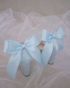 a pair of white shoes with blue bows on them