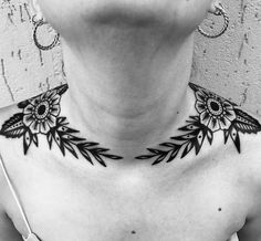 a woman's neck with black and white tattoos on it