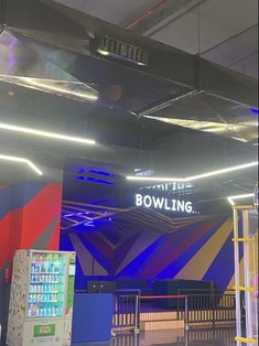 the bowling alley is brightly lit up with blue and red lights on it's ceiling