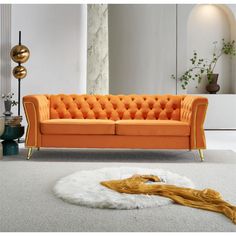 an orange couch sitting on top of a white rug