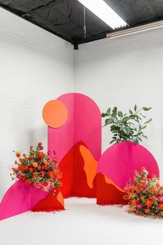 three planters are sitting on top of a large pink sculpture in the middle of a room