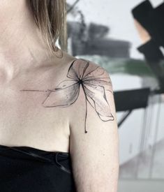 a woman with a tattoo on her chest has a flower in the shape of a leaf