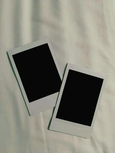 two polaroid frames sitting on top of a white sheet