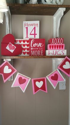 valentine's day decorations are displayed on shelves in a room with pink and white decor