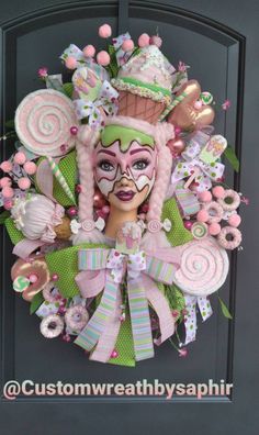 a wreath made to look like a woman's face with pink and green decorations