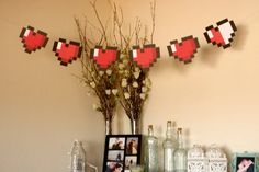 a table topped with pictures and vases filled with flowers next to a wall hanging