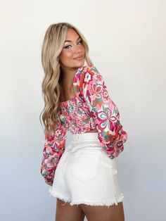 Experience a timeless fusion of fashion and comfort with the Retro Groove Top. Crafted from soft satin with a stretchy smocked back panel, this cropped piece presents a unique look with a floral print, square neckline, and balloon sleeves. Perfect for making a statement, it's fun, chic, and sure to elevate any ensemble. 100% Polyester Hand wash cold separately. Stretch Floral Print Crop Top For Day Out, Trendy Stretch Crop Top With Floral Print, Spring Fitted Crop Top With Elastic Waistband, Fitted Crop Top With Elastic Waistband For Spring, Chic Spring Crop Top With Elastic Waistband, Fitted Smocked Back Crop Top For Spring, Fitted Pink Top With Elastic Waistband, Chic Spring Crop Top With Smocked Bodice, Chic Fitted Crop Top With Elastic Waistband